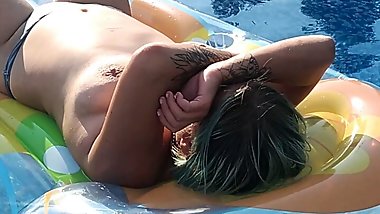 relaxing in the pool on a mattress sunbathing naked